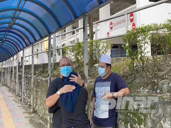 Dr Mohd Izani memeluk adik bongsunya, Izyan hazwani, 30, yang tidak dapat menahan kesedihan atas tragedi yang menimpa Allahyarham Mohd Irfan Mohamed Rawi, 44.