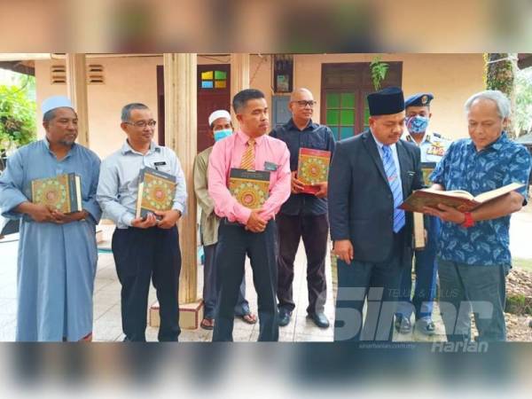 Muhammad Nasir (kanan) menunjukkan kandungan tafsir yang terdapat di dalam al-Quran sumbangan WUIF.