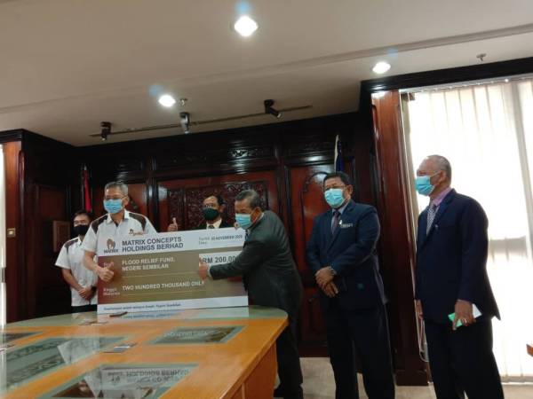 Simbolik penyerahan sumbangan RM200,000 daripada Kong Soon (dua dari kiri) kepada Aminuddin (empat dari kiri) di Wisma Negeri, Seremban hari ini.
