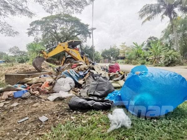Pekerja SWM Environment Sdn Bhd mengangkut sampah menggunakan jengkaut