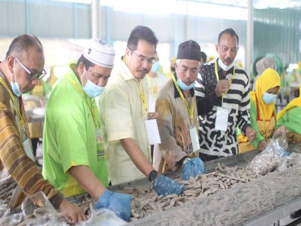 Rapuan@Sharuddin (dua dari kiri) bersama Pengarah Jabatan Pelancongan Terengganu, Huzairil Nizam Ibrahim (tiga dari kiri) ketika majlis perasmian kilang baharu di Kampung Pulau Kerengga, Marang Ahad lalu.