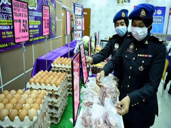 Dua anggota Penguatkuasa Perdagangan Dalam Negeri dan Hal Ehwal Pengguna (KPDNHEP) Negeri Sembilan Nurul Ain (kiri) dan Nur Hanuna (kanan, depan) memeriksa tanda dan barangan kawalan ketika pelancaran Skim Harga Maksimum Musim Perayaan Deepavali 2020, peringkat negeri yang dirasmikan oleh Pengerusi Jawatankuasa Bertindak Kesihatan, Alam Sekitar, Koperasi dan Kepenggunaan, S. Verrapan, hari ini. - Foto Bernama