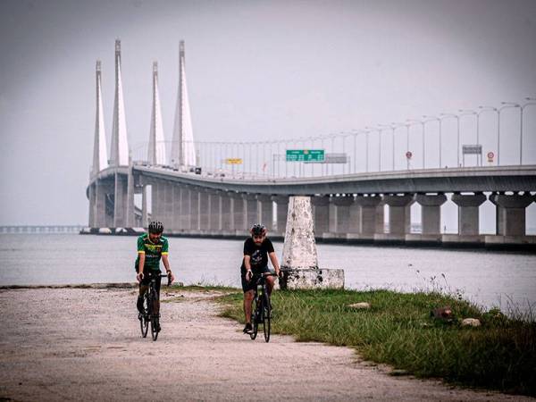 Dua orang penunggang basikal dilihat mematuhi prosedur operasi standard (SOP) yang ditetapkan oleh Majlis Keselamatan Negara (MKN) dengan bergerak dalam kumpulan kecil ketika beriadah di sekitar persisran pantai Jambatan Sultan Abdul Halim Muadzam Shah ketika tinjauan pelaksanaan Perintah Kawalan Pergerakan Bersyarat (PKPB) hari ini.