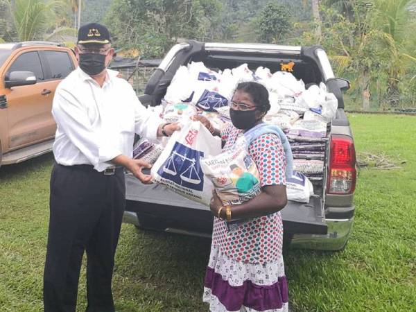 Noh (kiri) menyampaikan sumbangan Deepavali kepada penduduk di Kuil Ladang Mary di Bestari Jaya hari ini.