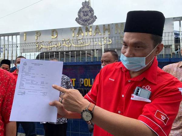 Ketua Penerangan Bersatu Kelantan, Bahari Mohd Noor menunjukkan laporan yang dibuat di IPD Tanah Merah di sini hari ini.