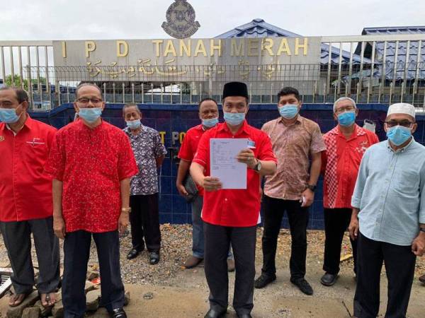 Ketua Penerangan Bersatu Kelantan, Bahari Mohd Noor (depan, dua kanan) menunjukkan laporan yang dibuat di IPD Tanah Merah melibatkan isu fitnah terhadap Perdana Menteri, Tan Sri Muhyiddin Yassin di sini hari ini.