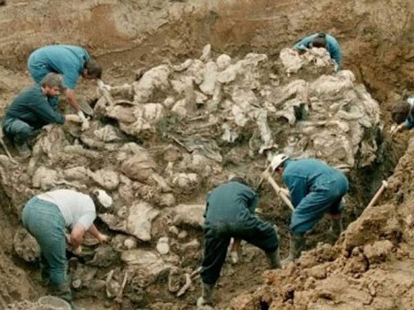 Anggota-anggota forensik daripada sebuah tribunal jenayah perang antarabangsa menggali sebuah lubang dan menemui timbunan mayat akibat Perang Bosnia di sebuah kampung di Sarajevo, pada tahun 1996. - Foto AFP