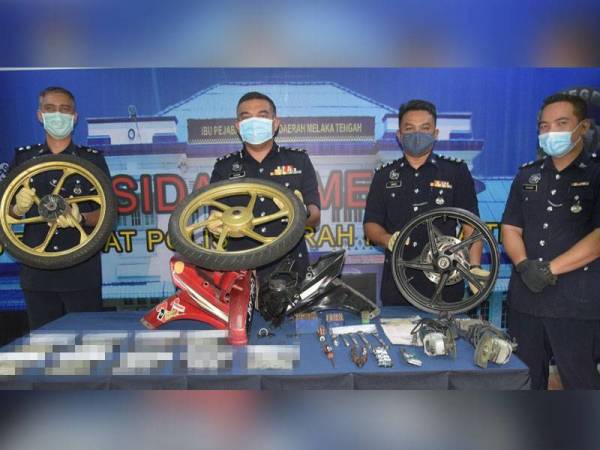 Afzanizar (tiga,kanan) menunjukkan sebahagian komponen motosikal yang telah dileraikan ketika sidang media di Ibu Pejabat Polis Daerah (IPD) Melaka Tengah di Banda Hilir, di sini, hari ini.