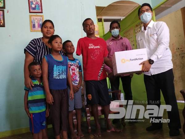 Pengurus MyFundAction Cawangan Perak, Ahmad Umair Zulkefli (kanan) menyampaikan bantuan kotak makanan sempena program Rezeki Ummat Deepavali di daerah Kampar.