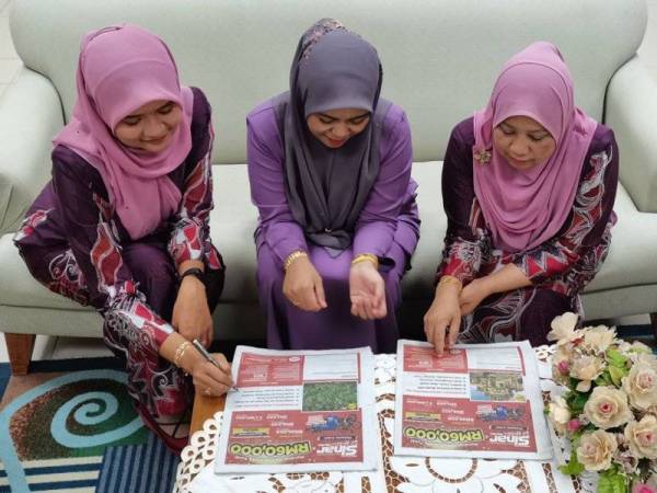 Roslaily (kiri) bersama dua rakan sekerjanya, Zailaini Awang, 40 (kanan) dan Noor Salasiah A Rahim, 28 mengisi waktu rehat tengah hari dengan berbincang mencari jawapan Peraduan Sinar Harian Di Hatiku di pejabat mereka di JPJ Terengganu.