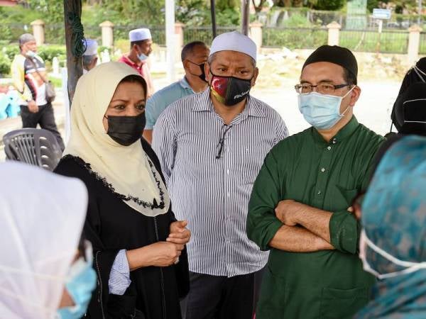 Shahrizat berbual dengan anak sulung Allahyarham Zaleha, Datuk Dr Zurin Adnan Abd Rahman selepas selesai pengkebumian di Tanah Perkuburan Islam Taman Ibukota, Setapak, hari ini. - Foto Bernama

