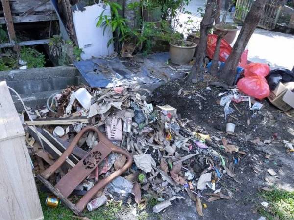 Barangan penduduk yang rosak dilanda banjir kilat dikumpul untuk dilupuskan.