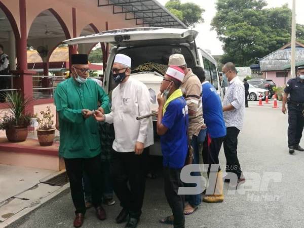 Aznel (kiri) mengiringi jenazah Allahyarham dari Masjid Jamek Gerik sehingga ke Tanah Perkuburan Islam Kampung Padang, Gerik hari ini.