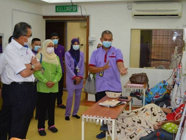 Ketua Pegawai Korporat TNB, Datuk Roslan Ab Rahman (kiri) mendengar penerangan mengenai proses hemodialisis daripada seorang petugas perubatan ketika majlis penyerahan sebuah mesin dialisis kepada Pusat Yayasan Kebangsaan Negara (YKN) di Kota Bharu pada 28 September lalu.