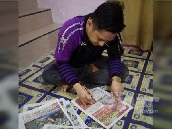 Muhammad Khalis menyiapkan jawapan Peraduan Sinar Harian Di Hatiku.