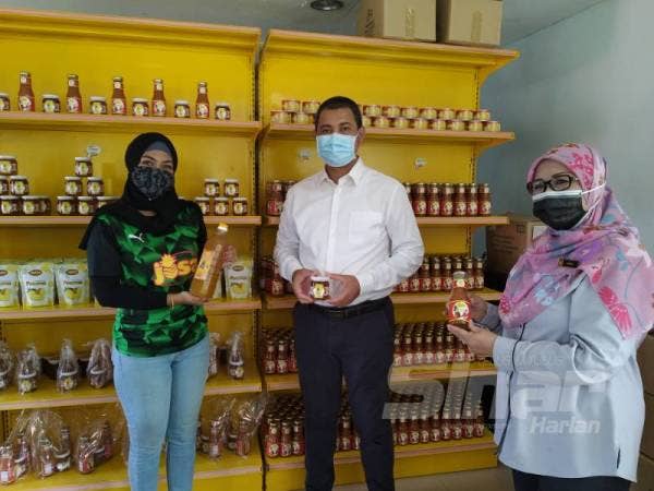 Nur Eleena ( kiri) dan Ruhaida (kanan) memperkenalkan produk Josa Pine kepada Dr Sahruddin ketika lawatan beliau ke Kampung Parit Selangor, Pontian pada Ahad lalu. 