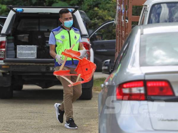 Anggota polis memegang kerusi dipercayai digunakan mangsa memukul anaknya.