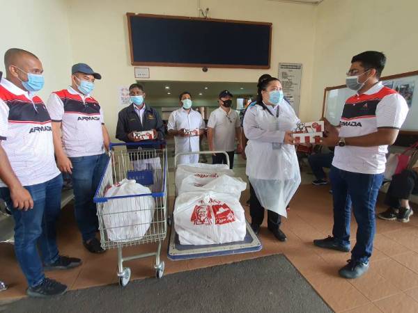 Muhammad Shameer (kanan) menyampaikan pek makanan kepada petugas di Hospital Pulau Pinang di Georgetown hari ini. 