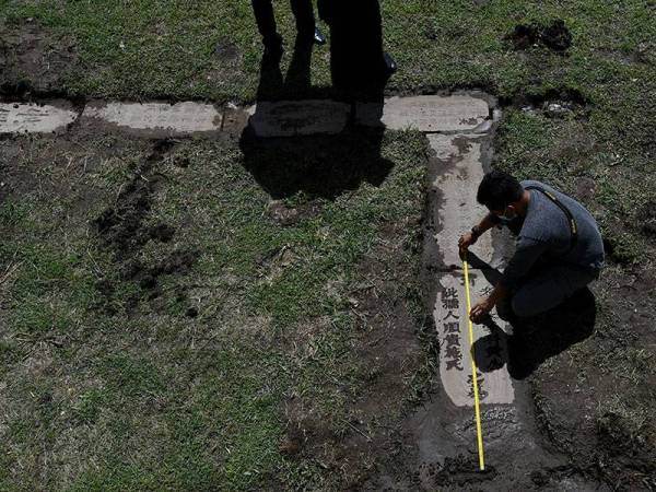 Penolong Kurator Unit Arkeologi Perbadanan Muzium Pahang Khairul Amir Abdul Karim mengukur panjang dan lebar dipercayai batu nisan daripada zaman Dinasti Qing pada abad 17 hingga 20 yang ditemui di hadapan rumah penduduk di Kampung Pekan Lama, dekat sini hari ini.