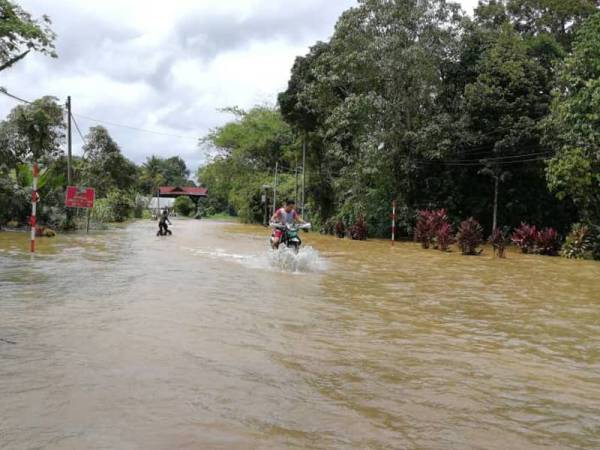 Salah seorang penduduk meredah banjir di Kampung Matang, Hulu Terengganu semalam.