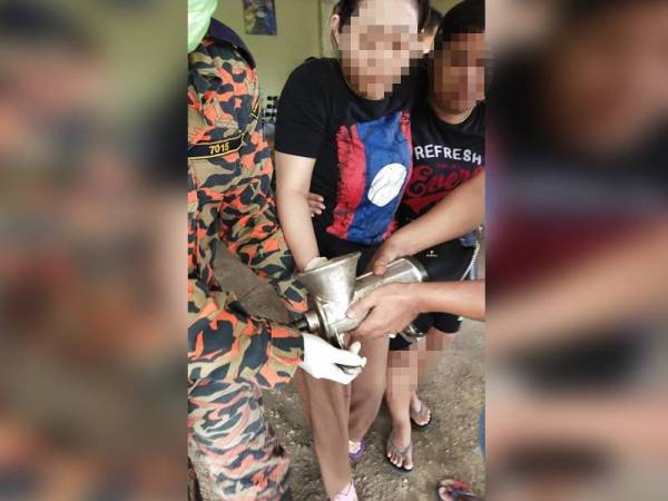 Rasmi Ehnui dibantu anggota bomba akibat tangannya yang tersepit dalam mesin pengisar ikan di Kampung Mertua, Pengkalan Kubor, Tumpat hari ini.