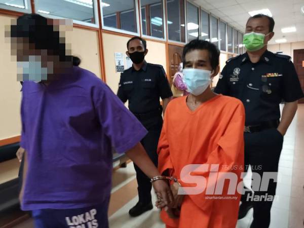 Tertuduh, Fadzir (kanan) dibawa keluar dari Mahkamah Sesyen Kuala Kangsar hari ini, selepas mengaku tidak bersalah mengugut ibu kandung.