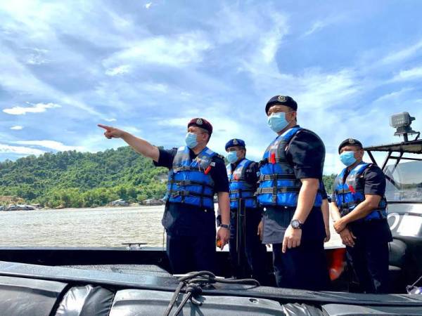 Mazli (kiri) bersama Habibi (kanan) memantau perairan Kampung Numbak yang dikenakan PKPD pada 16 November lalu.