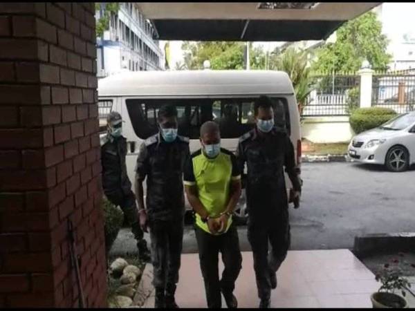 Mohd Basyaruddin (tengah) dihadapkan ke Mahkamah Sesyen Kuala Kangsar atas tuduhan menyeludup migran warganegara India.