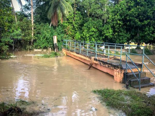 Air Sungai Garing yang melimpah selepas hujan lebat menyebabkan banjir di kawasan kampung ketika tinjauan di Kampung Bukit Tambun hari ini. - Foto Bernama