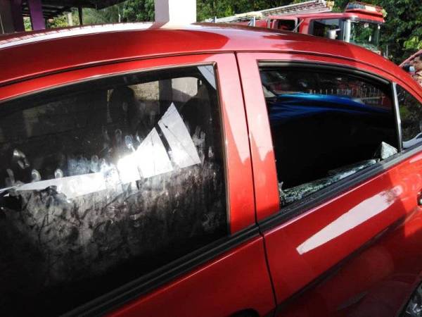 Anggota bomba terpaksa memecahkan tingkap belakang kereta untuk mengeluarkan mangsa yang terperangkap di Taman Widuri, Sungai Jawi, Nibong Tebal petang tadi.