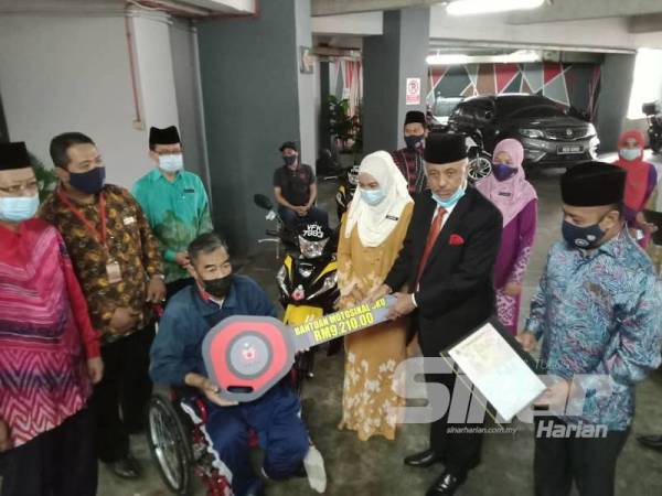 Syed Hussien menyantuni penerima sumbangan motosikal ketika Majlis Penyampaian Sumbangan MAIWP-Prihatin Kasih Asnaf di Dewan Seminar MAIWP, Bangunan Perkim kelmarin.