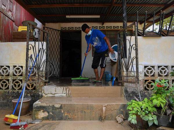Sukarelawan setempat bergotong royong membersihkan sebuah rumah penduduk warga emas yang terjejas susulan banjir kilat semalam ketika tinjauan di Kampung Gadek Dalam, hari ini.