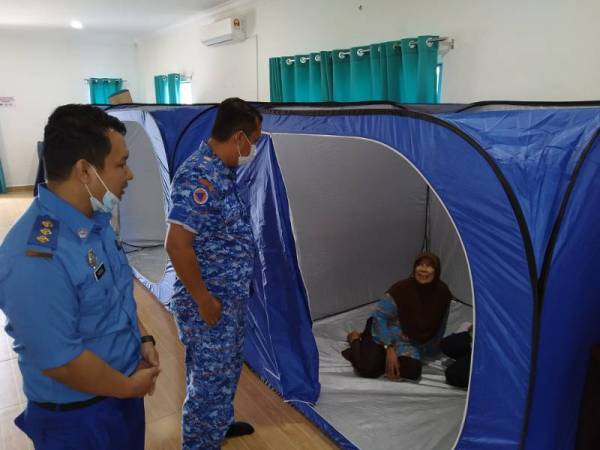 Kamal (dua dari kiri) meninjau keadaan penduduk yang ditempatkan di PPS Dewan Masjid Jamek Kampung Ulu Pulai pagi tadi.