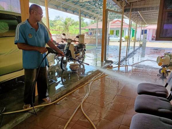 Misron Kordi, 64, melakukan kerja-kerja pembersihan selepas kediamannya di Kampung Chepor Dalam, Chemor dinaiki air akibat banjir hari ini.