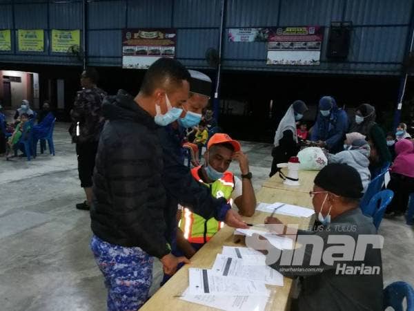 Pihak berkuasa membantu mangsa membuat pendaftaran di pusat pemindahan sementara Sekolah Kebangsaan Tok Jembal, Kuala Nerus.
