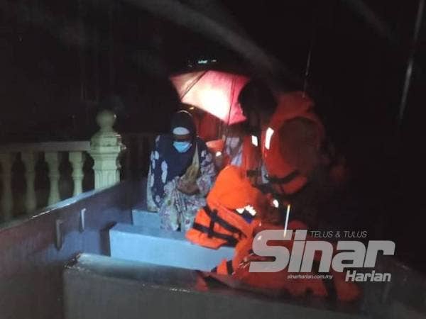 Anggota Angkatan Pertahanan Awam Malaysia membantu mangsa di Kampung Binjai, Chendering, Kuala Terengganu berpindah.