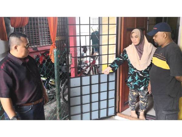 Salamiah bersama suaminya dan Zulkifli (kiri) menunjukkan jeriji pintu rumahnya bergoyang hingga terbuka malam tadi.