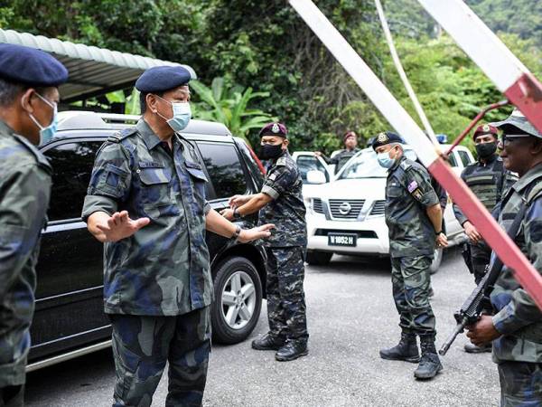 Ketua Polis Negara Tan Sri Abdul Hamid Bador (dua, kiri) bertanya sesuatu kepada anggota bertugas di Pos Sekatan Jalan Raya Taman Radzi selepas melawat kawasan berlakunya tembakan keatas seorang anggota Pasukan Gerakan Am (PGA) yang bertugas di sempadan Malaysia-Thailand yang maut dipercayai ditembak, awal pagi tadi.