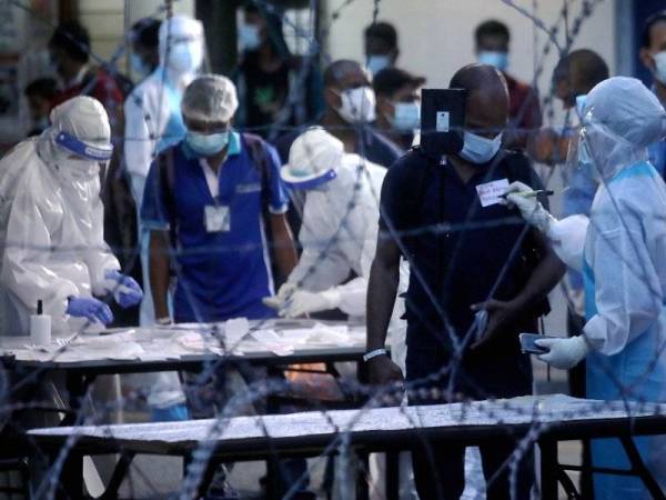 Petugas kesihatan membuat pemeriksaan terhadap pekerja Top Glove berikutan penularan wabak Covid-19 di Asrama Pekerja Top Glove Meru di Klang. - Foto Bernama