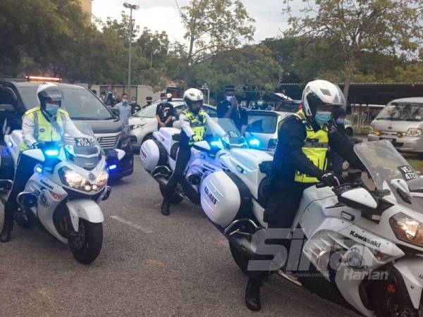 Anggota polis mengiringi kenderaan pengurusan yang membawa jasad mendiang Koperal Baharuddin untuk dihantar ke Kem Bidor Perak hari ini.