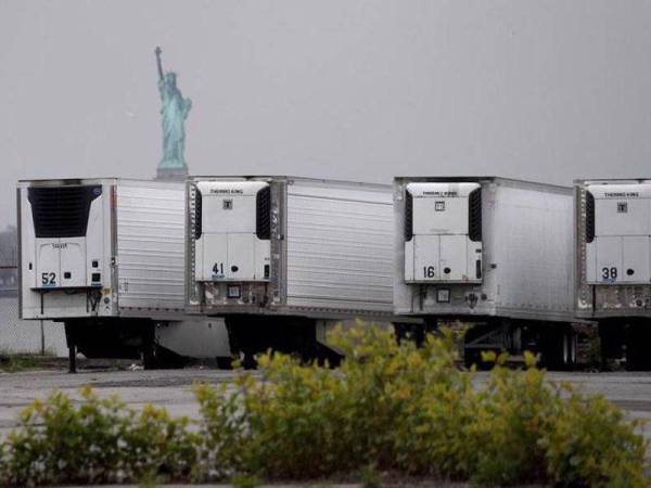 Trak sejuk beku yang dijadikan sebagai rumah mayat sementara ditempatkan di South Brooklyn Marine Terminal di New York. - Foto: Agensi