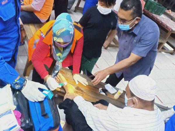 Petugas APM dan Jabatan Kebajikan Masyarakat (JKM) memeriksa mangsa banjir yang ditempatkan di salah sebuah PPS.