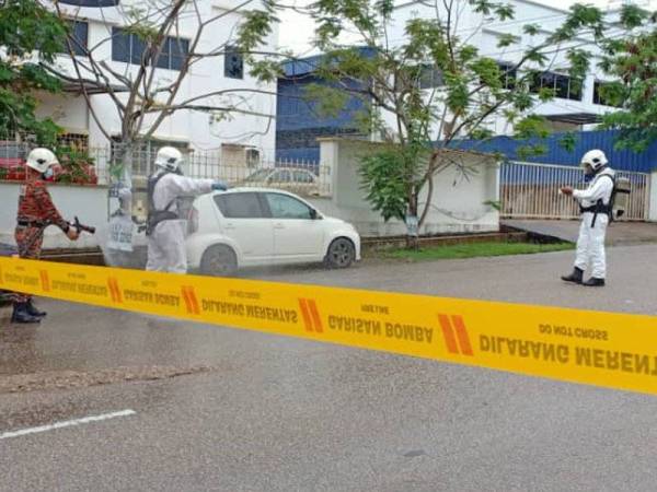 Anggota Hazmat dari BBP Gebeng dikerah bagi membantu membersihkan tumpahan bahan kimia di hadapan sebuah kilang ais di Indera Mahkota di sini, petang tadi. -Foto Bomba Pahang
