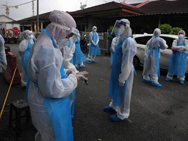 Kakitangan Top Glove Corporation Bhd memakai Peralatan Perlindungan Diri (PPE) ketika mengedarkan makanan kepada pekerja yang tinggal di kawasan yang dikenakan Perintah Kawalan Pergerakan Diperketatkan (PKPD) di Jalan Abadi 7 Meru Klang. - Foto Bernama