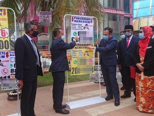 Shadan (tengah) menunjukkan sebahagian iklan haram yang diturunkan dalam tempoh Januari hingga hari ini.