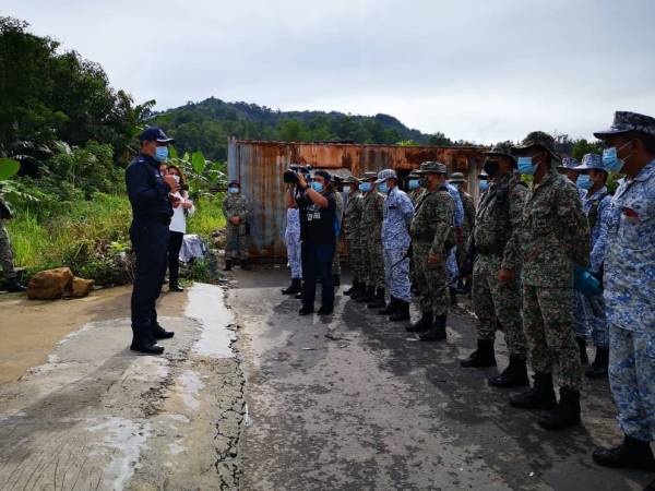 Mohd Hamizi memberi taklimat kepada anggota ATM dan TLDM mengenai proses pemasangan dawai di sekeliling kawasan PKPD di Taman Telipok Ria, Tuaran hari ini.