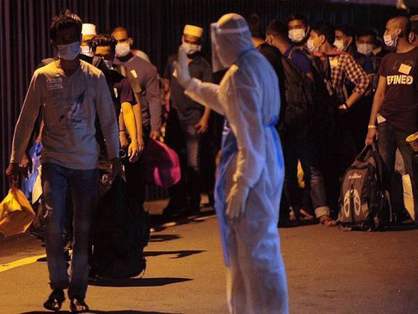 Sebahagian daripada 300 pekerja Top Glove yang dibawa keluar oleh petugas kesihatan berikutan penularan wabak Covid-19 di asrama pekerja Top Glove di Meru, Klang awal minggu ini. - Foto Bernama
