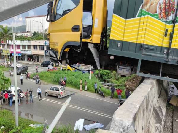 Lori tersangkut pada pengadang jalan di Kilometer 280.7 Lebuhraya Utara-Selatan, arah Selatan, berhampiran Nilai petang tadi menyebabkan kelindannya maut akibat tercampak ke jalan raya di bawahnya. - Foto bomba