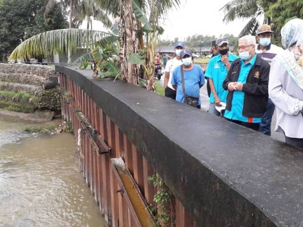 Hassan Karim meninjau lokasi tebing sungai yang runtuh sebelum ini hingga mengakibatkan banjir di Kampung Sungai Rinting D, Pasir Gudang hari ini.
