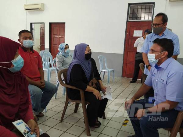 Nazir Hussin meluangkan masa berbual bersama penerima bantuan mangsa banjir di Dewan Kampung Paya, Kampong Bharu hari ini.